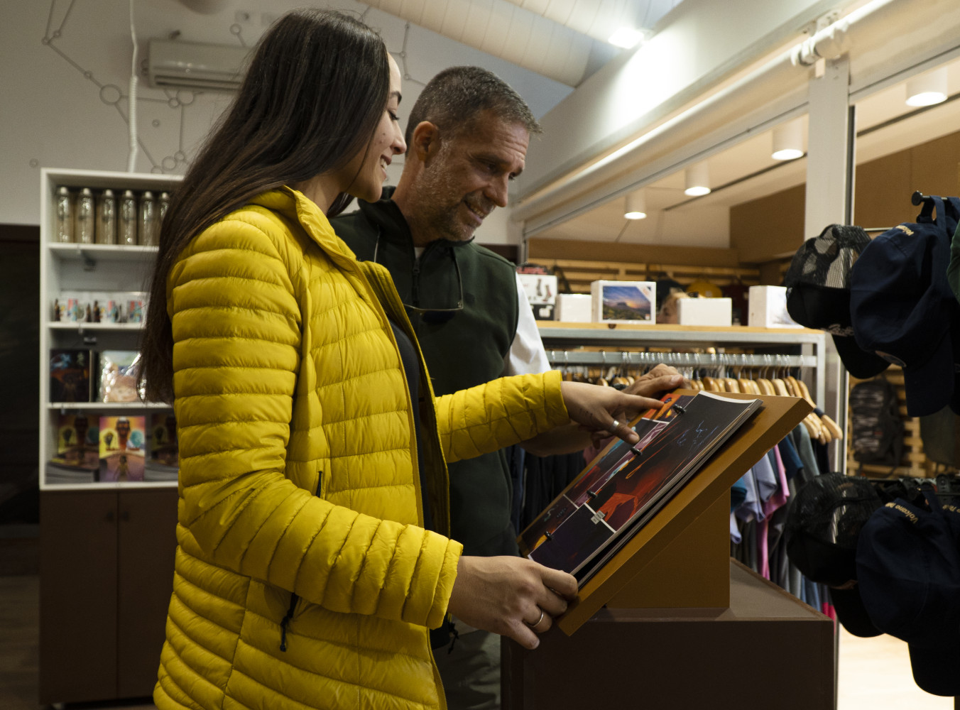 TPareja eligiendo su regalo en la tienda oficial de souvenirs del Centro de Visitantes del Teleférico del Teide